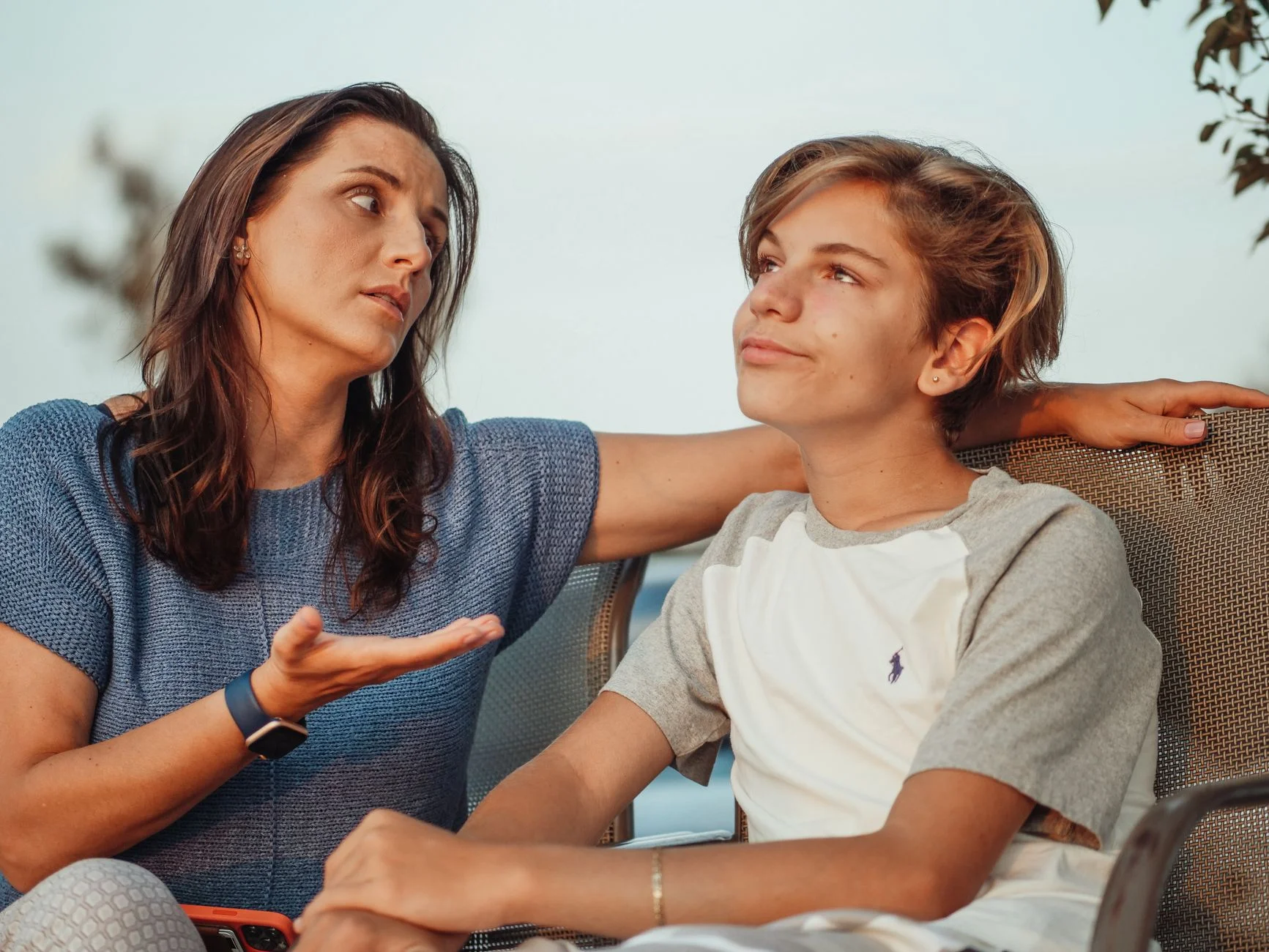 A mother talking calmly with her teenage son outdoors