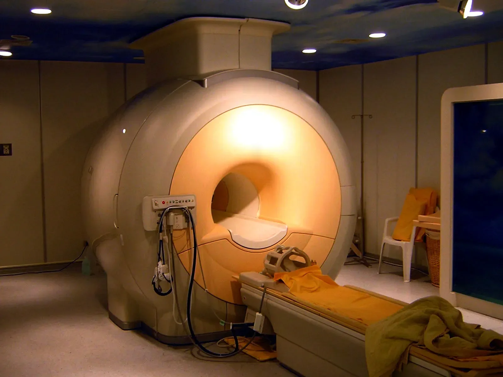 A hospital MRI scanner: a large ring-shaped superconducting magnet with a patient table leading into its bore