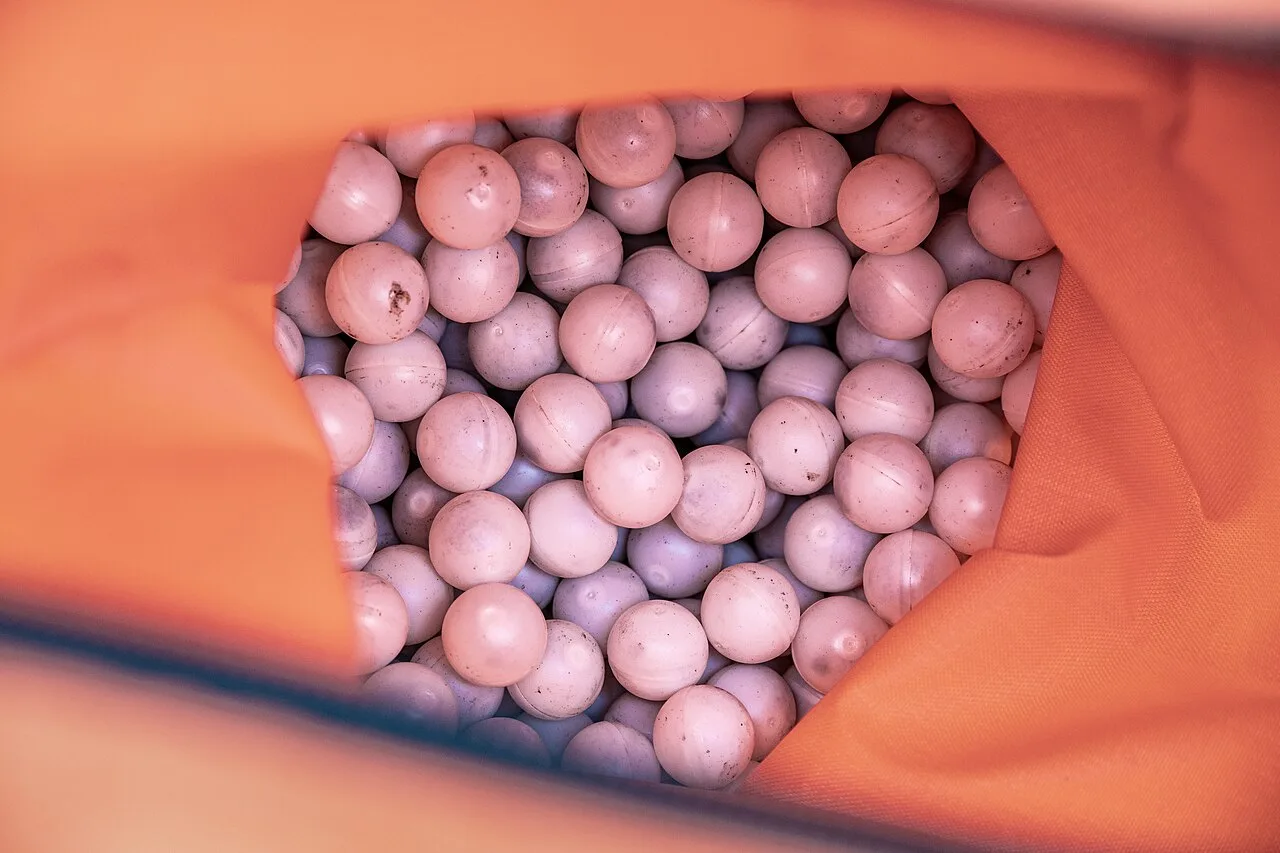 A bag full of small white plastic ignition spheres containing potassium permanganate, used for prescribed burns