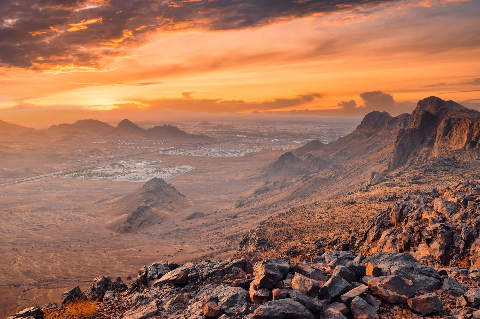 Rocky mountains and a wide stony desert plain at sunset near Medina, Saudi Arabia