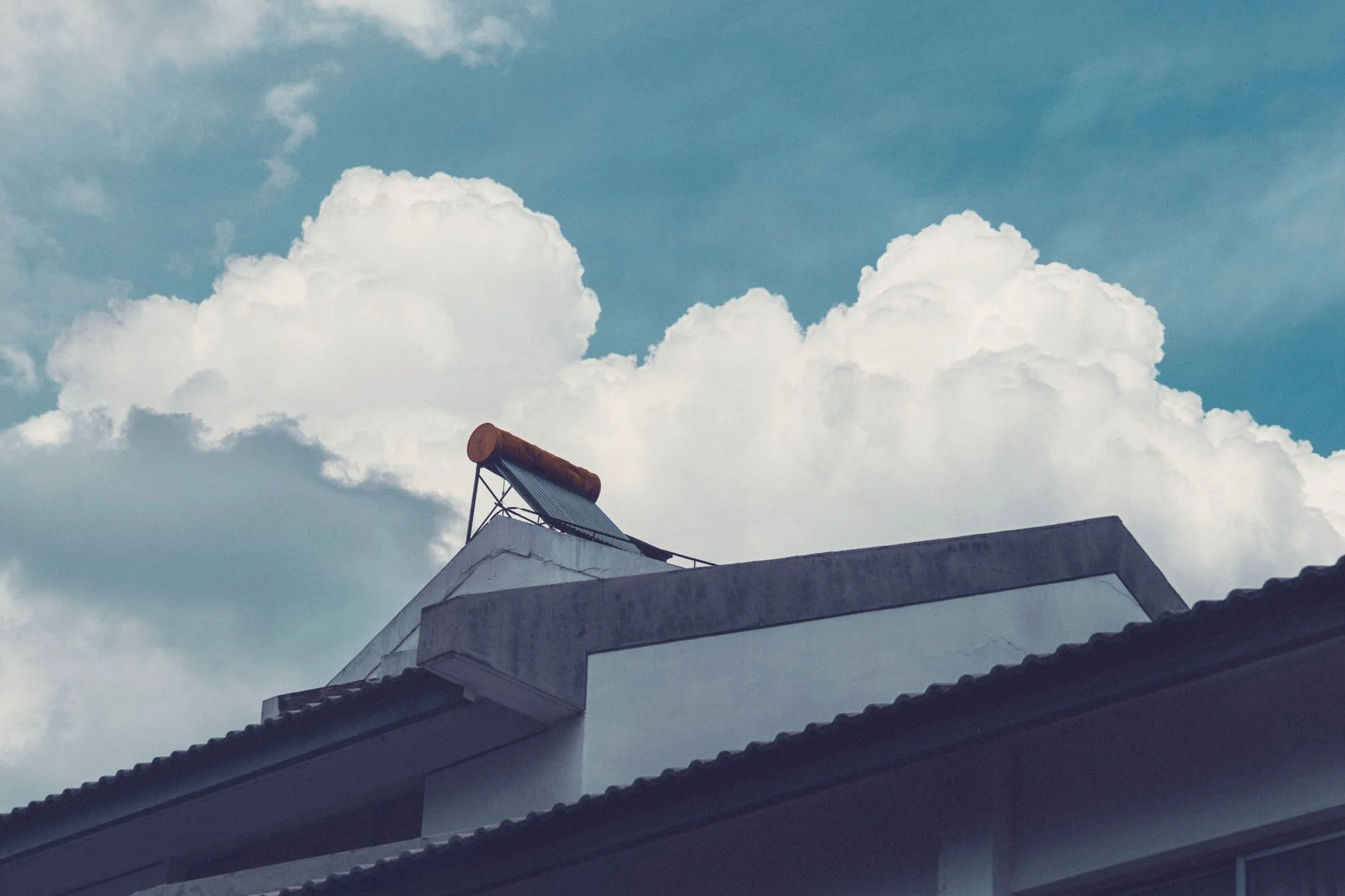 Solar water heater tank and collector on a building rooftop