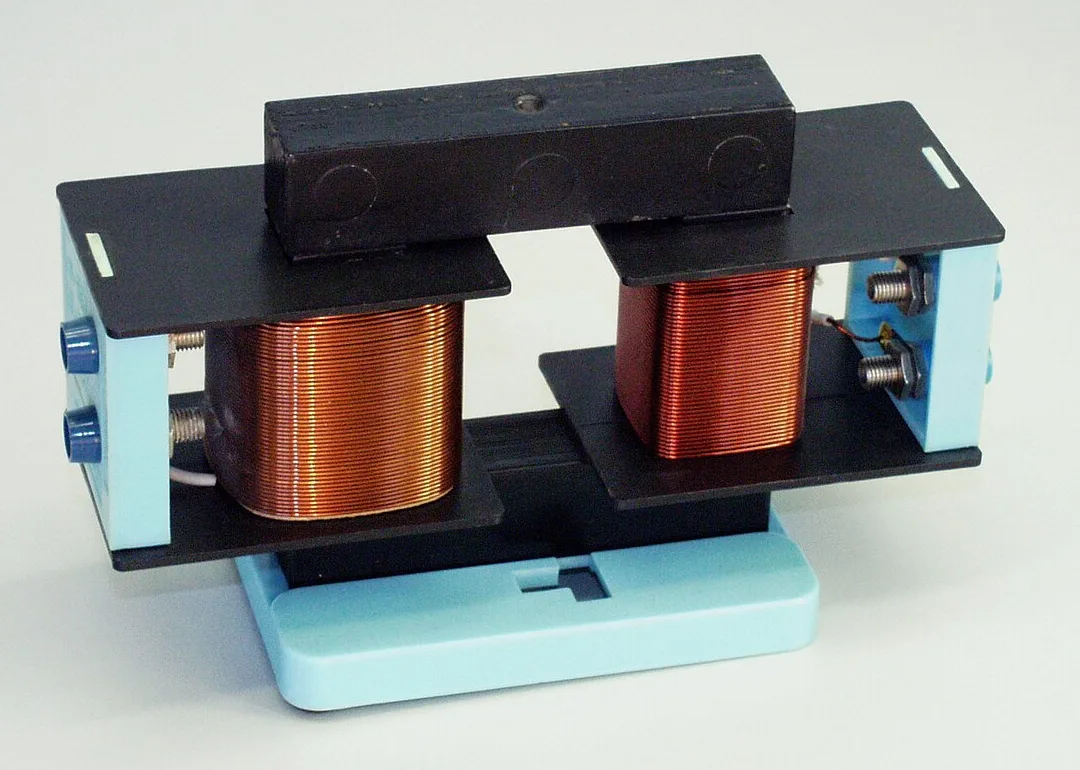 A school demountable transformer: two copper coils on a U-shaped iron core with an iron bar across the top completing the core