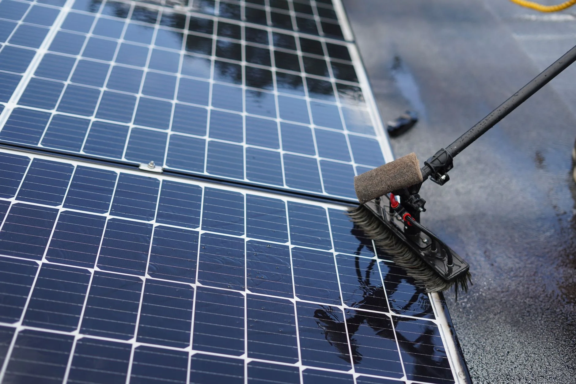 Soft brush on a long pole cleaning solar panels