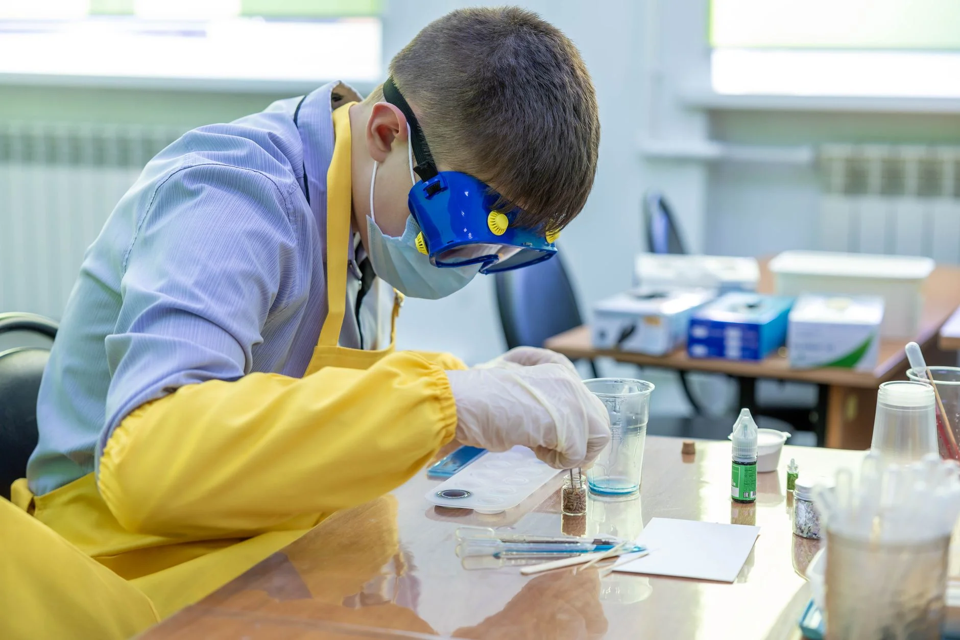 A student in a laboratory carrying out a chemistry practical with glassware