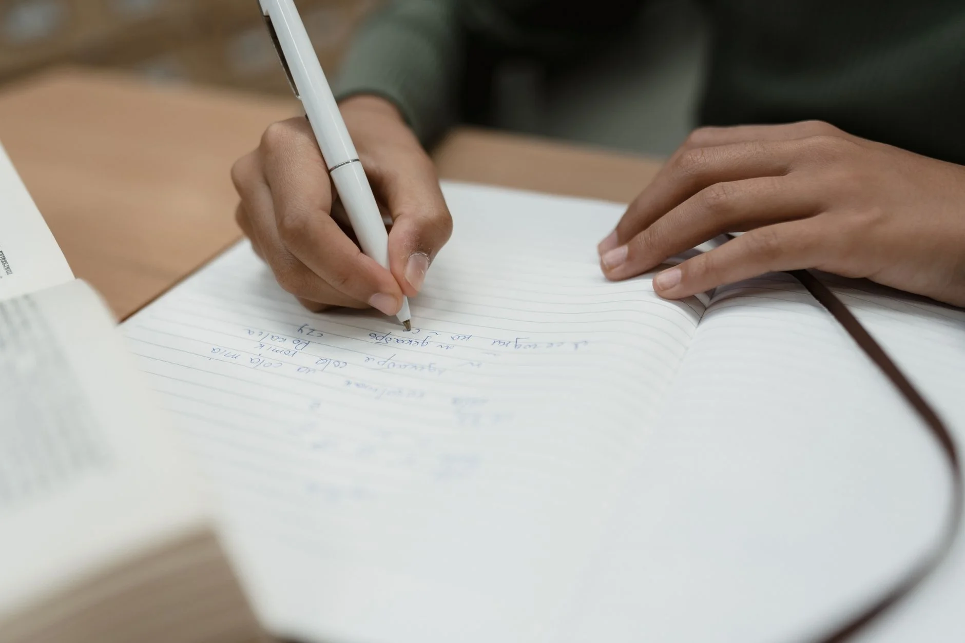 A student writing notes in a notebook