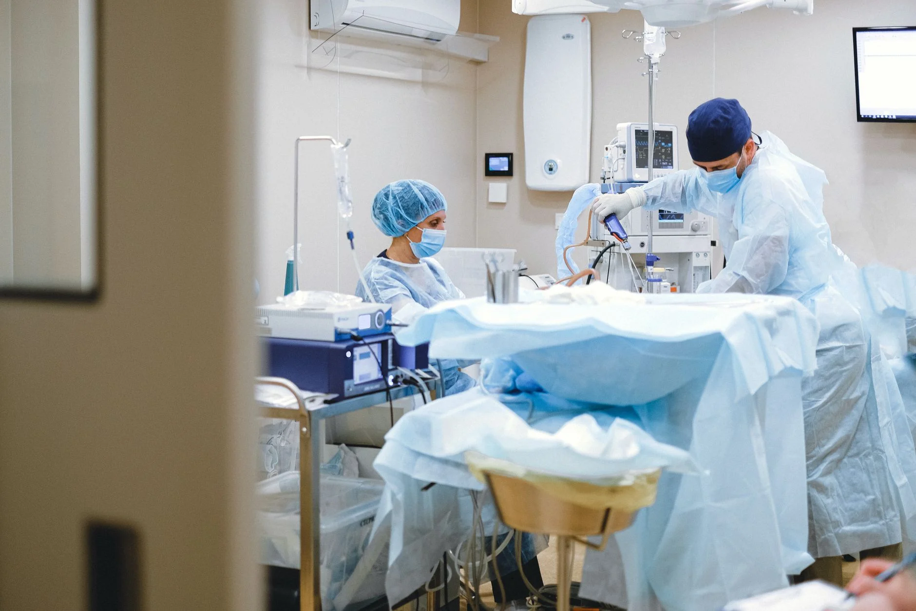 Surgeons and theatre staff in gowns and masks performing an operation