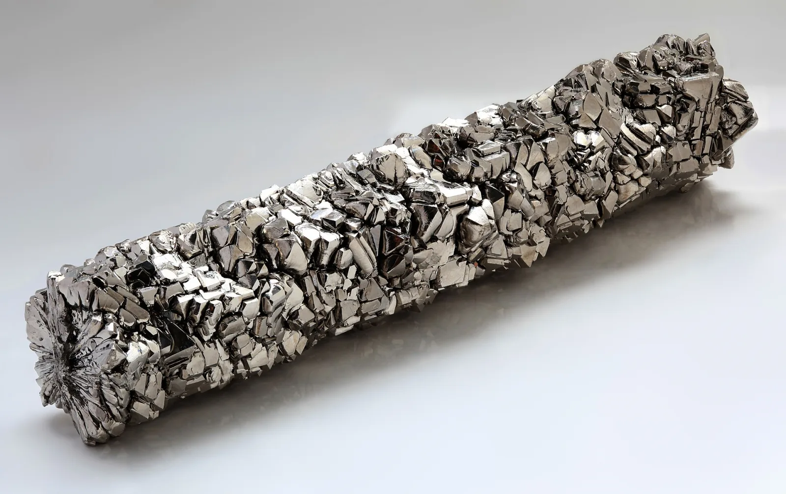 A bar of very pure titanium covered in shiny silver-grey crystals
