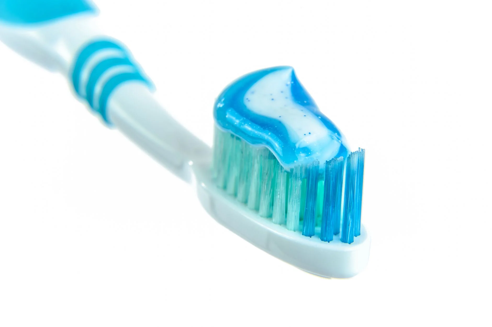 Blue and white toothpaste sitting on a toothbrush