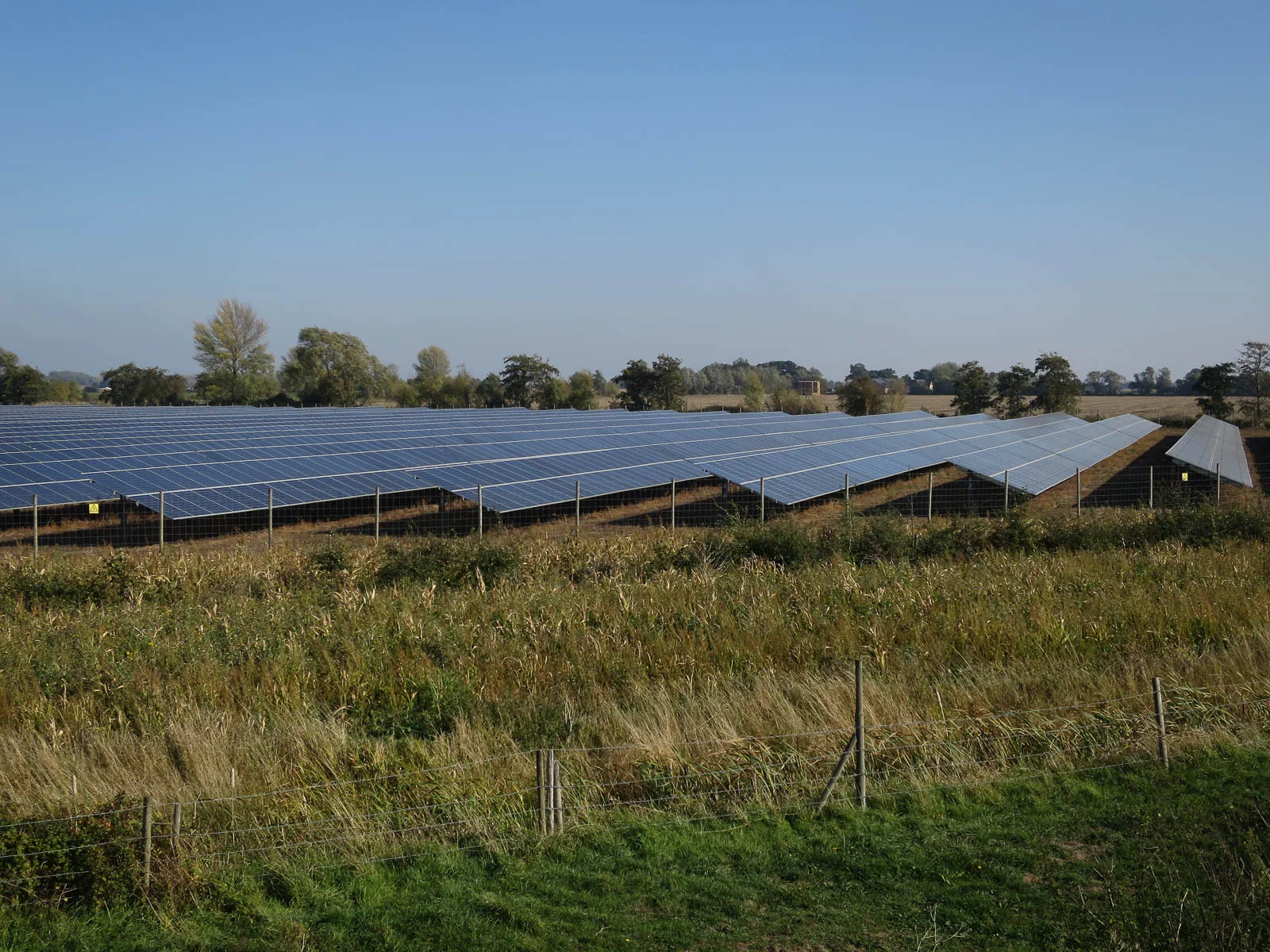 A solar farm in England with rows of solar panels in a field